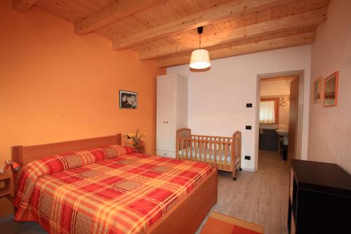 a bedroom with a bed and a crib in it at Agriturismo Val Codera in Verceia