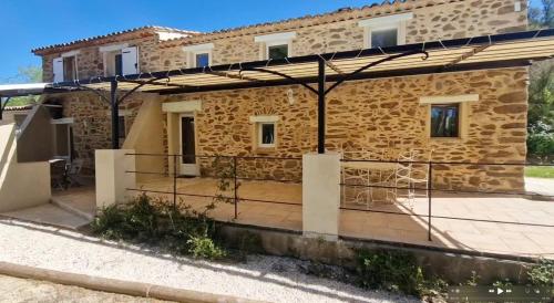 une maison en pierre avec une grande terrasse dans l'établissement Bastide La Maura dans le massif des Maures, à Vidauban