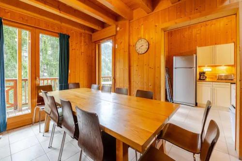 une salle à manger avec une grande table et des chaises en bois dans l'établissement Chalet Etoile, à Saint-Jean-dʼAulps