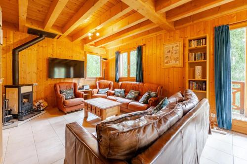 a living room with a leather couch and a fireplace at Chalet Etoile in Saint-Jean-d'Aulps