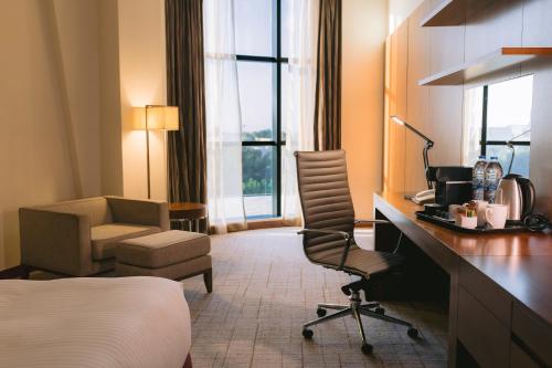 Pokój hotelowy z łóżkiem, biurkiem i krzesłem w obiekcie Holiday Inn Abu Dhabi, an IHG Hotel w Abu Zabi