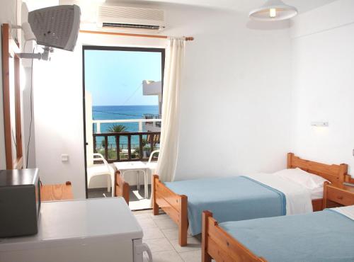 a room with two beds and a view of the ocean at Hotel Thisvi in Stalís