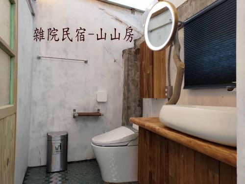 y baño con lavabo, aseo y espejo. en Yardbnb 2F, en Jiufen