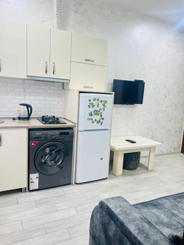 a kitchen with a washing machine and a table at Apartments NITA in Batumi