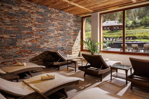 a living room with chairs and a brick wall at Teleferic Grand Hotel in Poiana Brasov