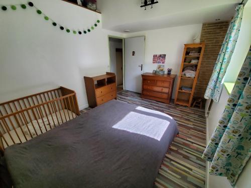 a bedroom with a bed and a dresser in it at Au Moulin du Miech in Salvagnac