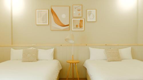 two beds sitting next to each other in a room at Cozy Blue B&B in Taitung City