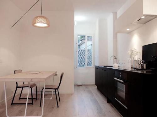 une cuisine avec une table et des chaises dans une pièce dans l'établissement L'aixois - Terrasse au cœur d'Aix-en-Provence #1, à Aix-en-Provence