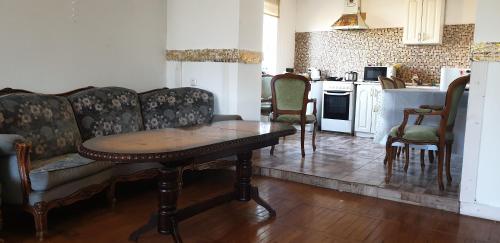 a living room with a table and chairs and a kitchen at Family Villa Sarapin in Kretinga