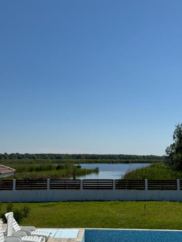 a swimming pool with a view of a body of water at Pensiunea Taisia in Murighiol