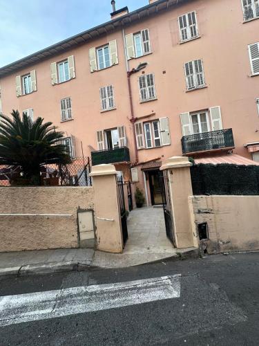 un grand bâtiment rose avec deux portes devant lui dans l'établissement Studio charmant et confortable, à Beausoleil