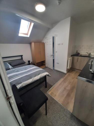 a bedroom with a bed and a kitchen in it at Exclusive Self-contained flat in Middlesbrough in Middlesbrough