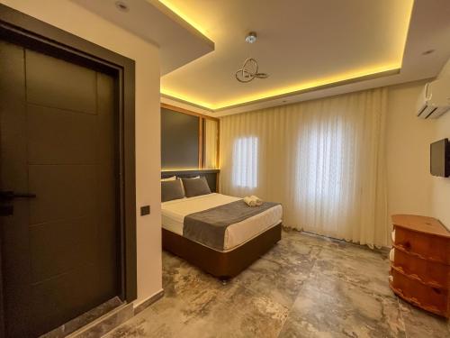 a bedroom with a bed and a sliding door at Rain Hotel in Kizkalesi
