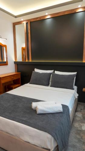 a bedroom with a large bed with a large headboard at Rain Hotel in Kizkalesi