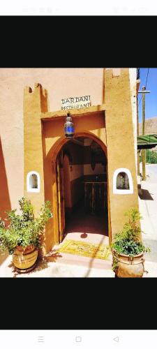 an entrance to a building with two potted plants at DAR DANI café restaurant in Boumalne