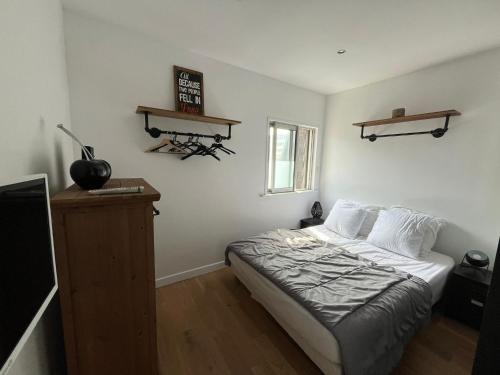 a bedroom with a bed and a tv in it at Appartement proche de la mer au Touquet in Le Touquet-Paris-Plage