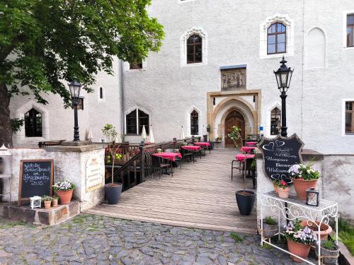a wooden walkway leading to a building with tables and chairs at Schloss Hotel Wurzen in Wurzen