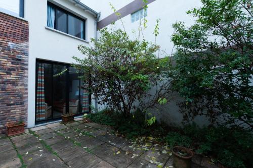 une maison avec un arbre devant un bâtiment dans l'établissement Superb Cozy Accommodation In Boulogne Billancourt, à Boulogne-Billancourt