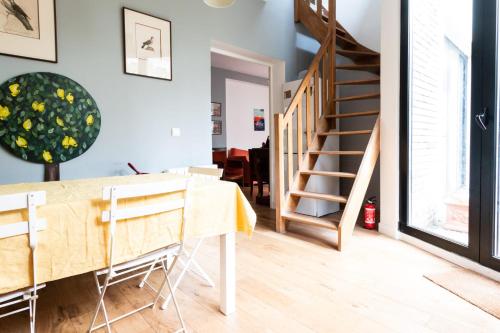 une salle à manger avec une table et un escalier dans l'établissement Superb Cozy Accommodation In Boulogne Billancourt, à Boulogne-Billancourt