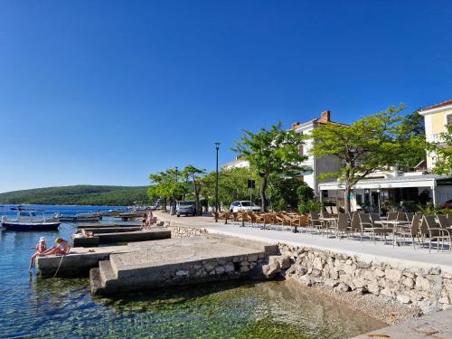 a group of people sitting on boats in the water at Apartman Valja - 55m2 - Sea View - Garden - Grill in Jadranovo