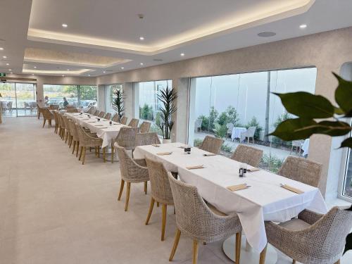 a dining room with tables and chairs and large windows at Belmoral Corporate Suites in Townsville