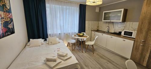 a room with a bed and a kitchen with a table at Willa Joanna in Gdańsk