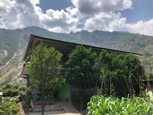 un edificio con árboles y montañas al fondo en Bless Break Guesthouse, en Narcheng