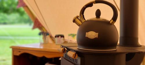 a black tea kettle sitting on top of a table at Park Farm Holidays Glamping in Lyndhurst