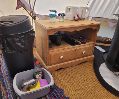 a small wooden table with a drawer with tools on it at Park Farm Holidays Glamping in Lyndhurst