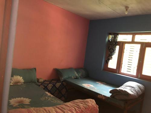 Habitación pequeña con cama y ventana en Bless Break Guesthouse, en Narcheng