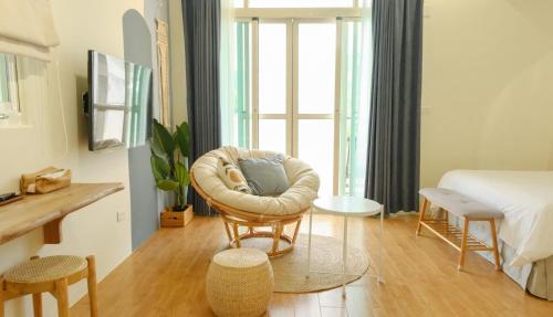 a living room with a chair and a bed at Cozy Blue B&B in Taitung City