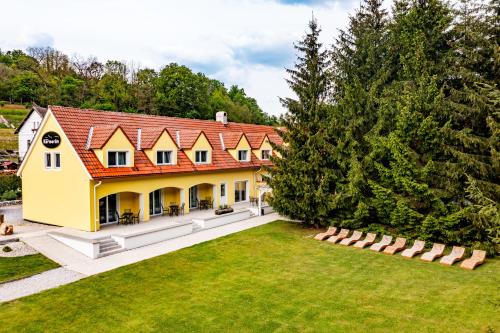 uma vista aérea de uma grande casa amarela com um telhado vermelho em Penzion Kormorán em Vranov nad Dyjí