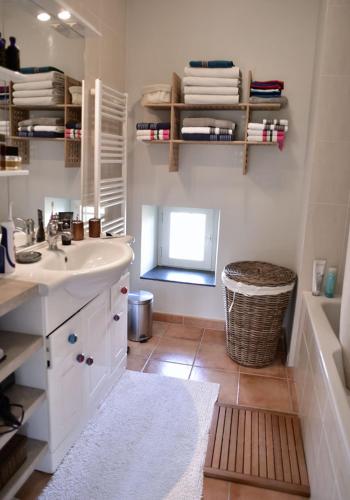 une salle de bain avec un lavabo et une baignoire dans l'établissement La ROBERTE : Mas provençal avec piscine Proche des Gorges de l'Ardèche, à Pont-Saint-Esprit