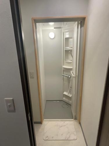 an empty refrigerator with its door open in a room at Guest House BONITO in Kochi