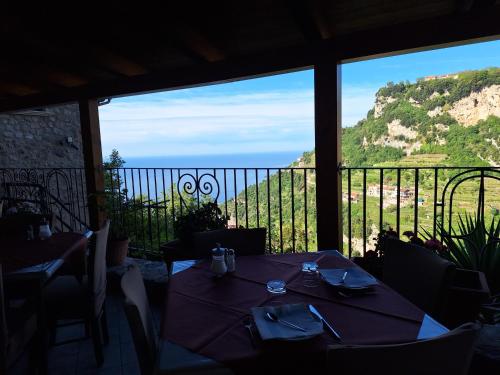 uma mesa num restaurante com vista para o oceano em Agriturismo Orrido di Pino em Agerola