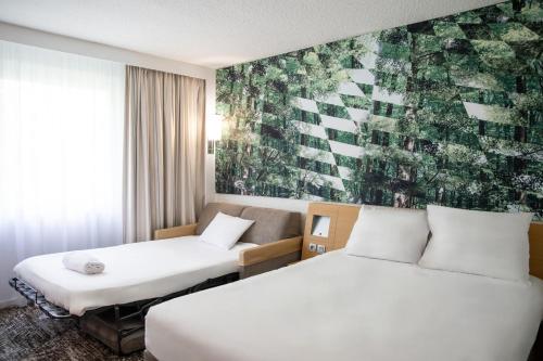 une chambre d'hôtel avec 2 lits et une fresque murale. dans l'établissement Novotel Saint Avold, à Saint-Avold