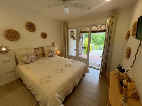 a bedroom with a bed and a sliding glass door at La Belle Rivière in Salernes