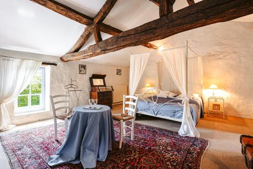 Schlafzimmer mit einem Bett und einem Tisch mit Stühlen in der Unterkunft Logis La Tour - Gîte La Tour in Saint-Laurent-de-la-Salle
