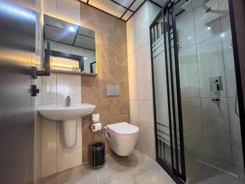 a bathroom with a toilet and a sink and a shower at Rain Hotel in Kizkalesi