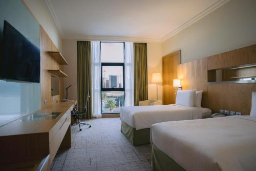 a hotel room with two beds and a large window at Holiday Inn Abu Dhabi by IHG in Abu Dhabi