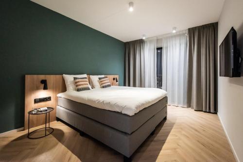 a bedroom with a bed and a green wall at Numa Amsterdam Docklands in Amsterdam