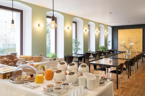 uma sala de jantar com uma mesa com pratos de comida em Hotel Johann em Berlim