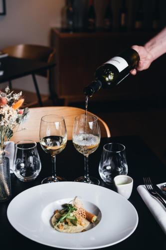 a person pouring wine into a plate of food at Boutique Hotel Villa du Taur in Toulouse