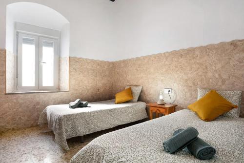 a room with two beds and a window at Casa Rural Cruce de Castro in Cádiz