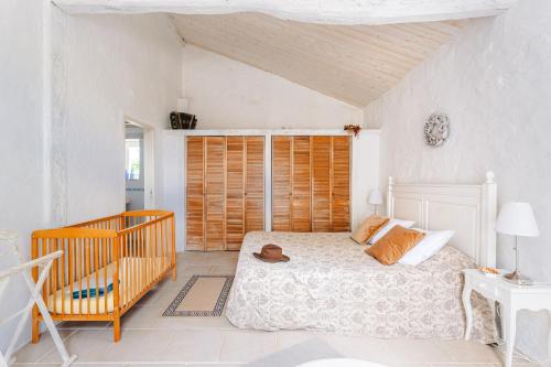 a bedroom with a bed and a crib at Logis La Tour - Gîte Orangerie in Saint-Laurent-de-la-Salle