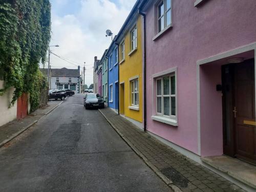 ulica z kolorowymi domami po stronie drogi w obiekcie Townhouse 2 Barrow Lane w mieście Carlow
