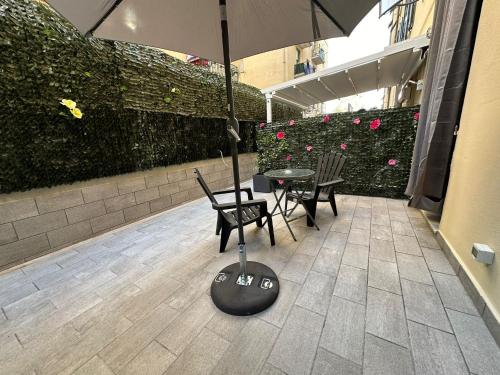 a patio with a table and chairs and an umbrella at Adam Eric in La Spezia