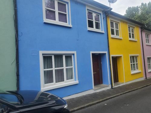 une maison bleue et jaune sur le côté d'une rue dans l'établissement Townhouse 2 Barrow Lane, à Carlow