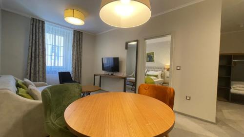a living room with a table and a couch at Hotel Radetzky in Sankt Gilgen