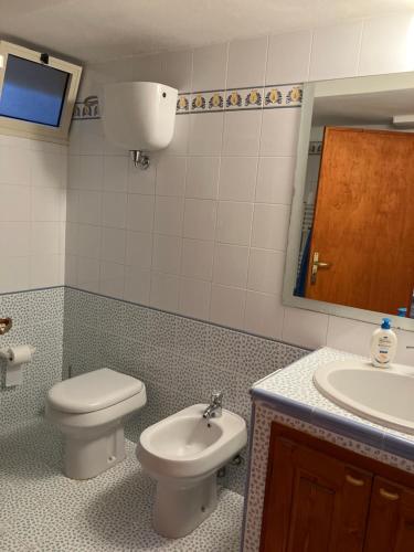 a bathroom with a toilet and a sink and a mirror at sala in Scauri